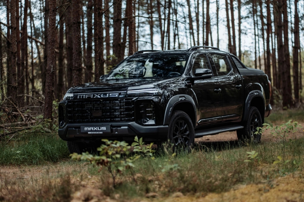 Svart Maxus T60 MAX i skogsterräng Svart Maxus T60 MAX i skogsterräng